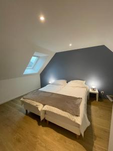 a bedroom with a large bed with a blue wall at Gîtes de Cohuta in Montfort-sur-Meu
