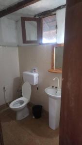 a small bathroom with a toilet and a sink at Marashi Villa in Nungwi
