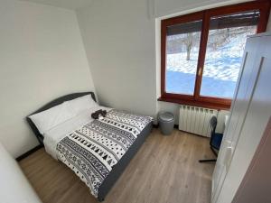 a small bedroom with a bed and a window at Lussuosa Suite in Montagna con WIFi e Netflix in Tarvisio