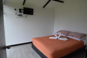 um quarto com uma cama com duas toalhas em CABAÑAS SALEKA Paipa 