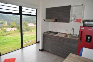 a kitchen with a red refrigerator and a large window at LA ESTANCIA DE FRANCIA Paipa in La Bolsa