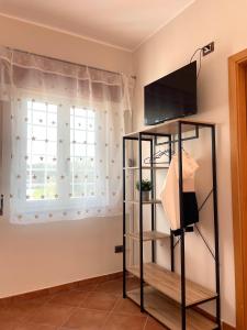 una camera con finestra e mensola con televisore di La casa di Isa a Lamezia Terme