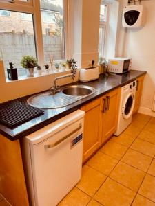 a kitchen with a sink and a washing machine at Two Bedroom, Off-road Parking in Ludgershall