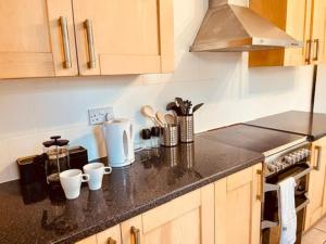 eine Küche mit einer Arbeitsplatte mit Tassen drauf in der Unterkunft Two Bedroom, Off-road Parking in Ludgershall