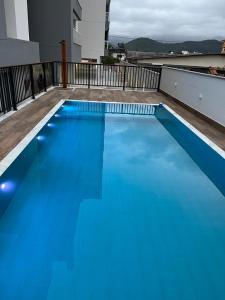 a blue swimming pool on top of a building at Apartamento Jardins Ubatuba in Ubatuba +8 photos