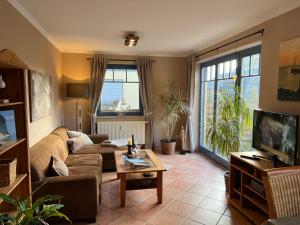 ein Wohnzimmer mit einem Sofa und einem TV in der Unterkunft Ferienwohnung Baumann in Prerow