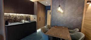 a kitchen with a table and chairs and a counter at Woodside Story in Kopaonik