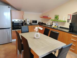 a kitchen with a table with a vase of flowers on it at Beautiful View 2 - Arco da Calheta - Ilha da Madeira in Arco da Calheta