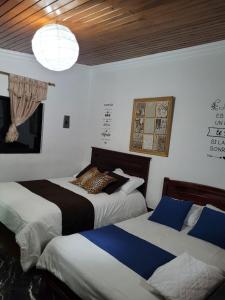 a bedroom with two beds and a chandelier at Casa de Mármol in Riobamba