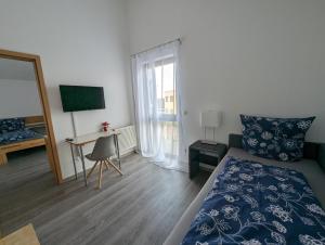 1 dormitorio con cama, escritorio y ventana en Pension Victoria en Steinmauern