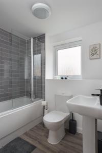 a white bathroom with a toilet and a sink at Two Bedroom Apartment - Milton Keynes By Aryas Properties in Broughton