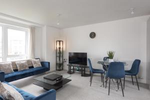 a living room with a blue couch and a table at Two Bedroom Apartment - Milton Keynes By Aryas Properties in Broughton
