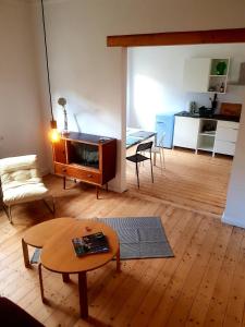 a living room with a coffee table and a kitchen at Ferienwohnung am Schloss Colditz in Colditz