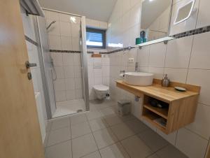 a bathroom with a sink and a shower and a toilet at Pension Victoria in Steinmauern +15 photos