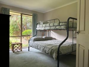 a bedroom with two bunk beds and a window at Family Holiday Home in Inverloch