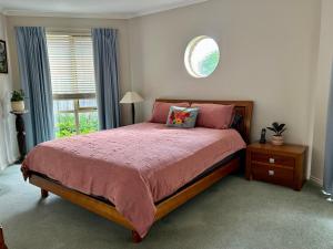 a bedroom with a large bed and a window at Family Holiday Home in Inverloch