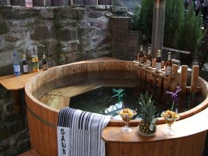 a wooden plunge pool with bottles and glasses of wine at Gaststätte & Pension Alte Mühle in Dorfchemnitz