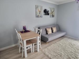 a living room with a table and a couch at Apartament Twoja Chwila in Stronie Śląskie