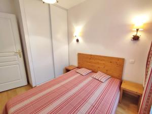 ein Schlafzimmer mit einem Bett mit zwei Kissen darauf in der Unterkunft La petite ourse, T2, centre Luchon, wifi, casier à skis, 4 personnes in Luchon