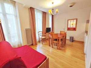ein Wohnzimmer mit einem roten Sofa und einem Tisch in der Unterkunft La petite ourse, T2, centre Luchon, wifi, casier à skis, 4 personnes in Luchon