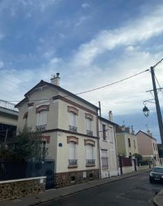 a large white building on the side of a street at Oasis de Détente et Évasion Urbaine au Cœur de la Ville in Colombes