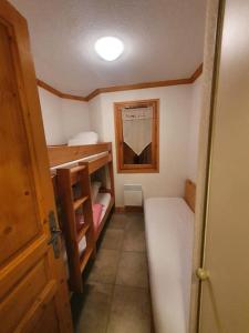 ein kleines Zimmer mit einem Etagenbett und einer Tür in der Unterkunft Chalet de la Grand Vy : Appart 6/7 personnes. in Valloire