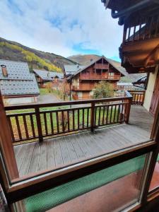 a wooden balcony with a view of a house at Chalet de la Grand Vy : Appart 6/7 personnes. in Valloire