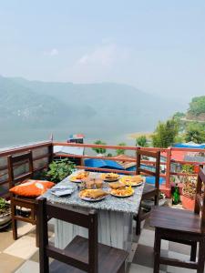 un tavolo con piatti di cibo in cima a un balcone di Hotel October Inn a Pokhara