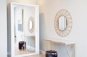 een hal met een spiegel en een kruk bij Luxury 2 Bedroom Apartment Near Train Station in Welwyn Garden City