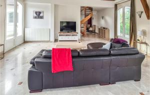 sala de estar con sofá de cuero marrón con manta roja en Beautiful Home In Lamorlaye With Wifi, en Lamorlaye