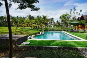 a swimming pool in the yard of a resort at Adil Villa & Resort in Ubud