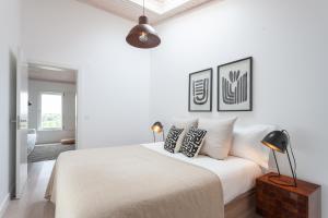 a white bedroom with a large bed with pillows at Tavira-Quinta da Janela Azul in Tavira