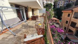 patio ze stołem, krzesłami i kwiatami w obiekcie Bedrock w mieście Salerno