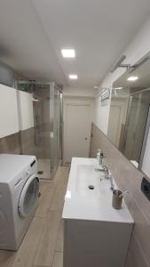 W łazience znajduje się pralka i umywalka. w obiekcie Bedrock w mieście Salerno