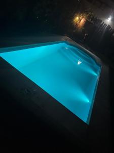 a swimming pool at night with blue illumination at Casa H6 in Maipú