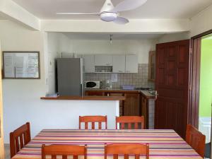 uma cozinha com uma mesa e cadeiras e um frigorífico em Villa Café - Appartement F3 à Sainte-Anne em Sainte-Anne