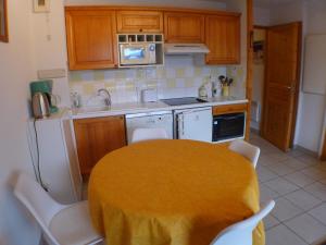 una cocina con una mesa con un mantel amarillo. en Appartement Samoëns, 3 pièces, 4 personnes - FR-1-629-101, en Samoëns