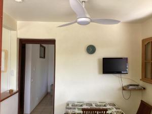 a room with a ceiling fan and a television on the wall at Villa Café - Appartement F2 à Sainte-Anne in Sainte-Anne