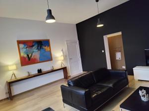 un salon avec un canapé en cuir noir dans l'établissement B&B Leopold Appartementen & studio's, à Saint-Trond 52 autres photos