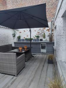 a patio with a table and an umbrella at B&B Leopold & Vakantiewongingen in Sint-Truiden