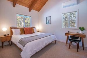 a bedroom with a bed and a desk and two windows at Three Rivers Basecamp - Meredith Lodging in Sunriver +72 photos