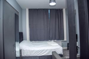 a bedroom with a bed in front of a window at Piccadilly Apartments in Bradford