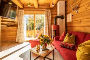 a living room with a red couch and a fireplace at The Kaprun Edition - Luxury Chalets & Style Suites in Kaprun