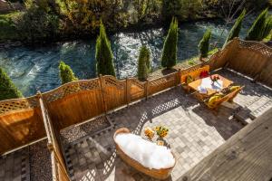 eine Badewanne auf einer Terrasse neben einem Fluss in der Unterkunft The Kaprun Edition - Luxury Chalets & Style Suites in Kaprun