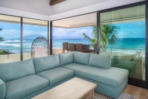 - un salon avec un canapé et une vue sur l'océan dans l'établissement Direct Oceanfront Penthouse, à Kahana