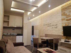 eine Küche und ein Wohnzimmer mit einem Sofa und einem Tisch in der Unterkunft Apartman K5 Milmari Resort in Kopaonik