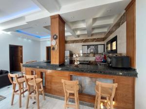 a kitchen with a bar with chairs and a counter top at فيلا ايجار فى الإسكندرية بجوار مطار برج العرب كينج مريوط in King Mariout