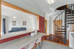 a living room with a staircase in a house at Camara de Lobos Duplex Apartment by HR MADEIRA in Câmara de Lobos