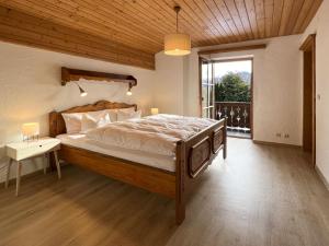 a bedroom with a large bed with a wooden ceiling at Chalet Horn by Apartment Managers in Kitzbühel