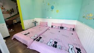 台南市にあるHaianStayのピンクベッド(猫付)が備わる客室です。